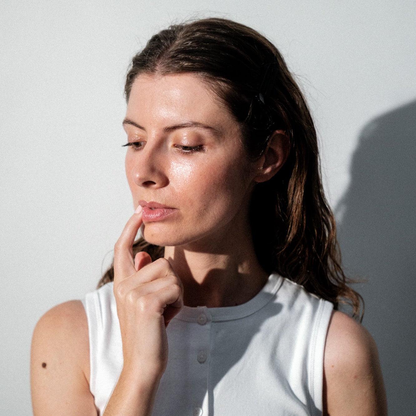 woman applying skin barrier protection to her lips in the form of an overnight lip treatment 